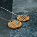 Wooden pendant necklace with metal accents on a dark surface