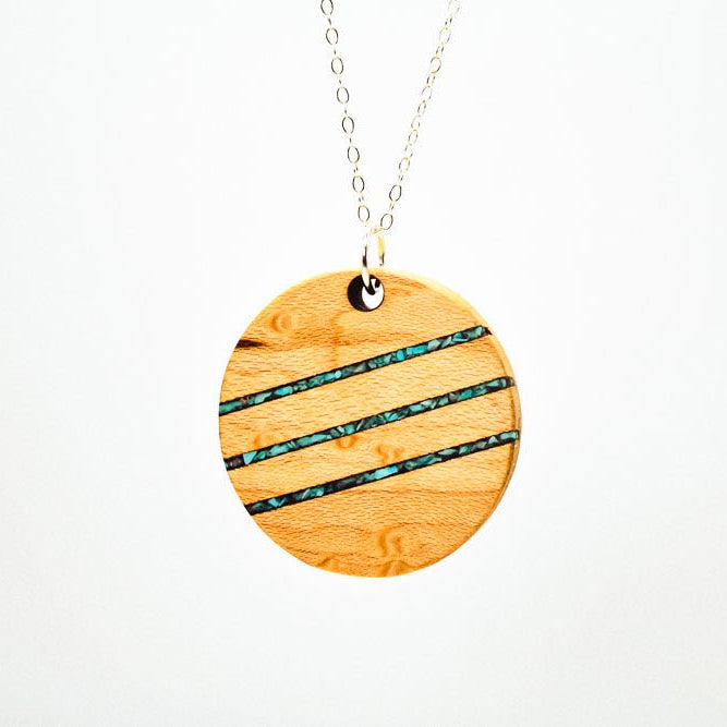 Wooden pendant necklace with blue accents on a white background
