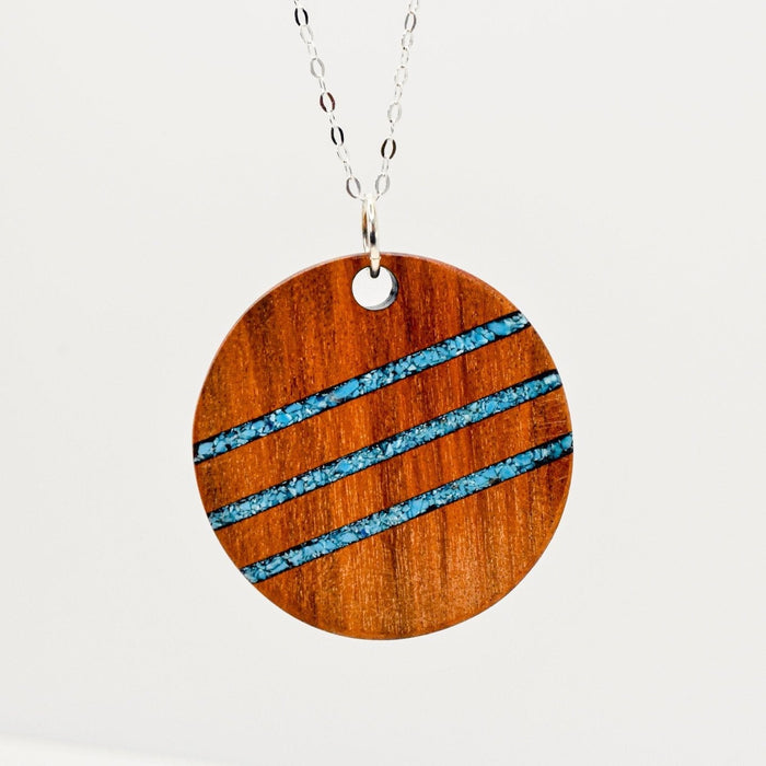 Necklace with a wooden pendant featuring blue stripes on a white background