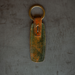 Leather key fob with a gold ring on a textured gray background