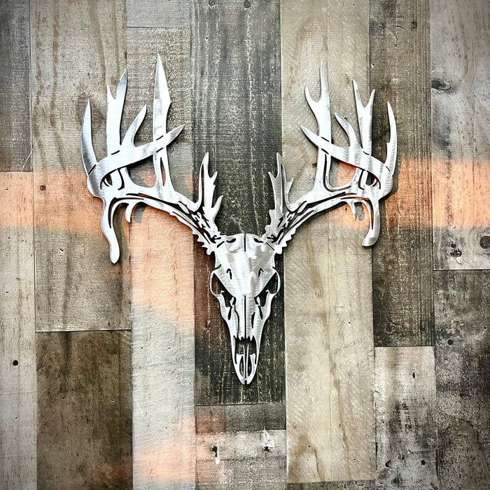 Metallic deer skull and antlers on a wooden panel background