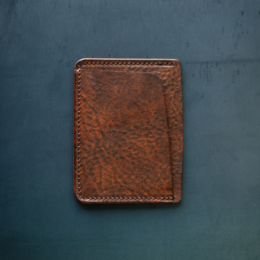 Brown leather wallet on a textured blue surface