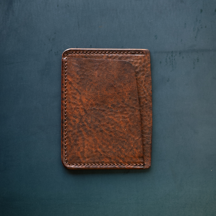 Brown leather wallet on a textured blue surface