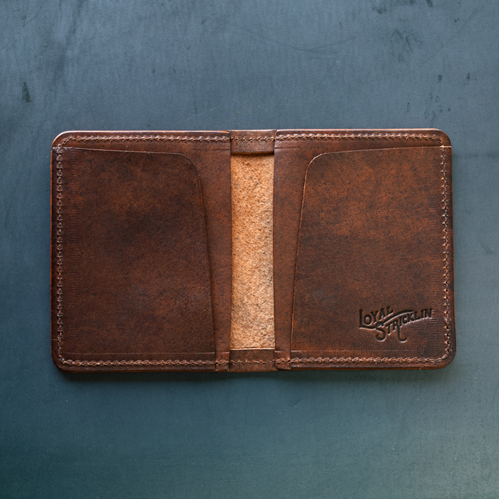 Brown leather wallet with visible brand logo on a textured blue background